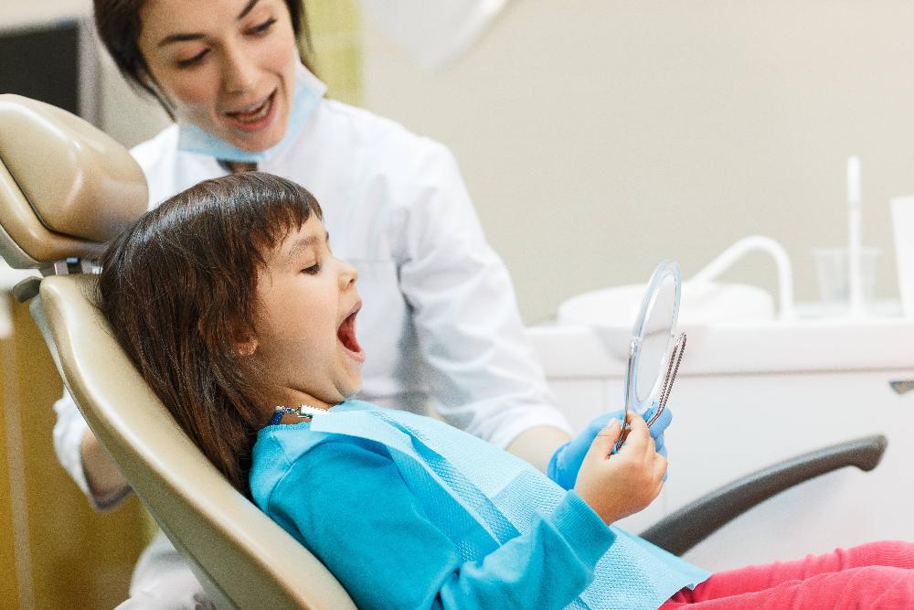 child sitting in dentist exam chair | dental exams st paul mn