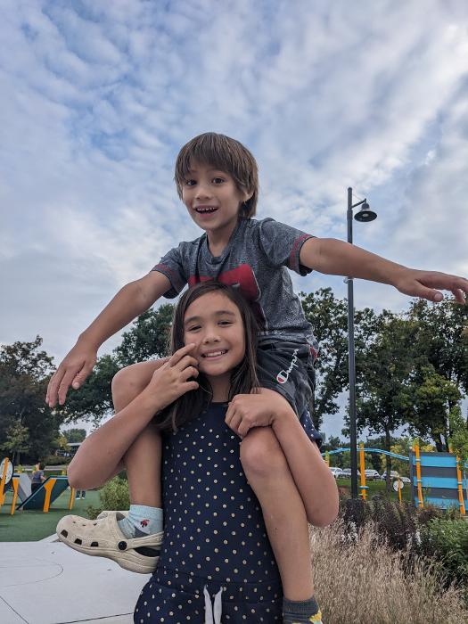 brother riding on his sister's shoulders