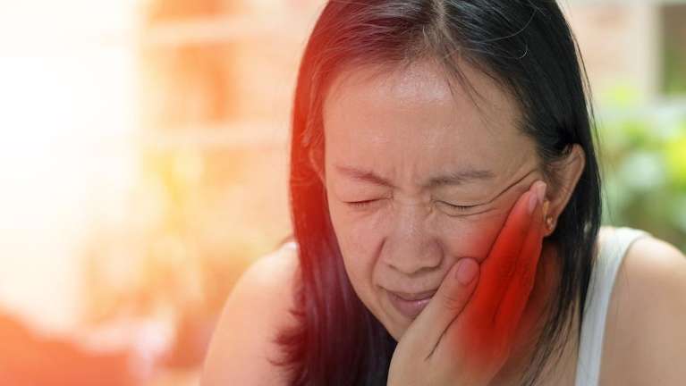 woman in pain holding jaw | root canals st paul mn